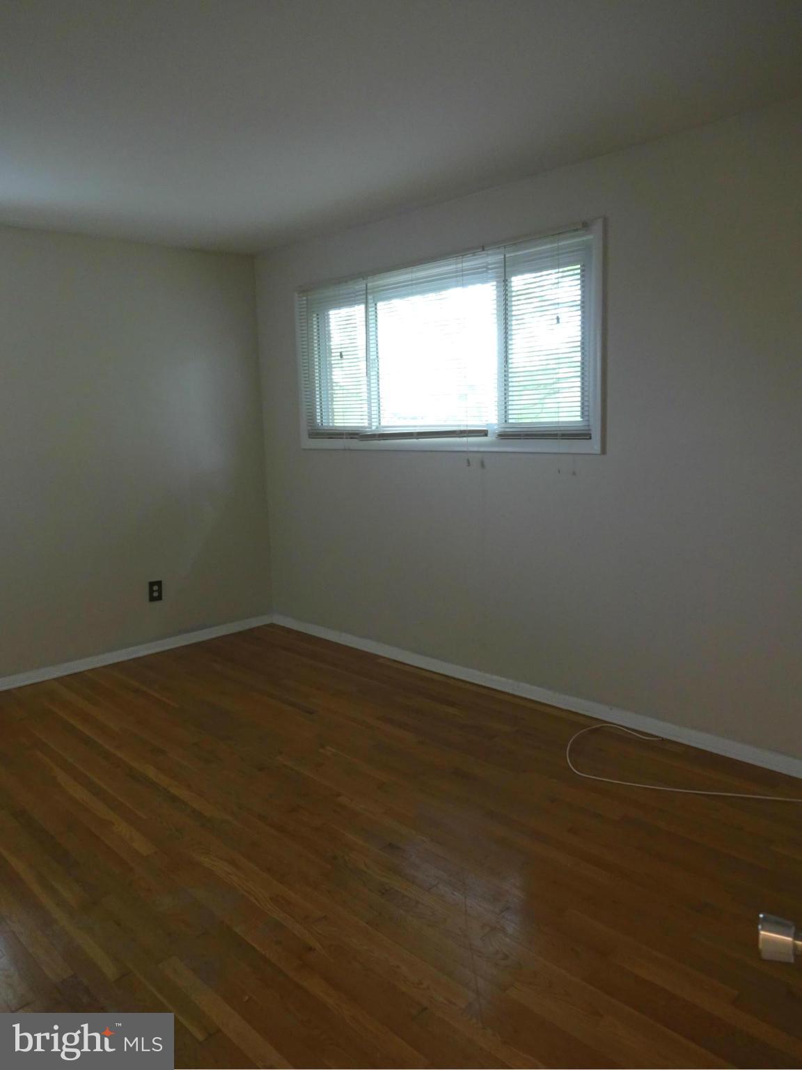 521 Epsom Road, Unit 2B Baltimore, MD 21286 - Photo 8 of 14 an empty room with wooden floor and windows