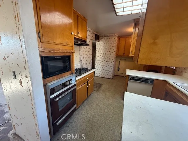 a kitchen with stainless steel appliances a stove and a microwave