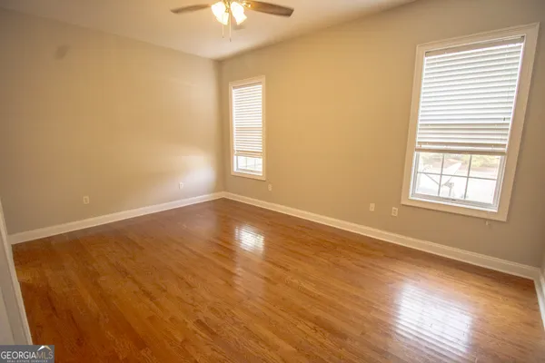 a view of an empty room with a window and wooden floor
