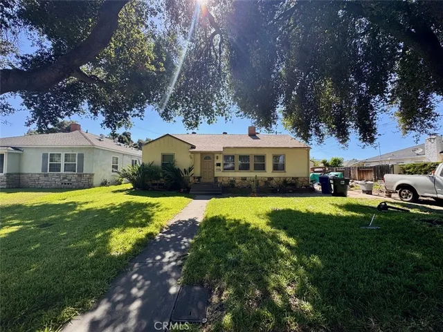 a front view of a house with a yard table and chairs under an umbrella