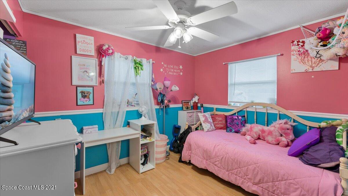 2255 King Richard Road Melbourne, FL 32935 - Photo 12 of 23 a bedroom with a bed a chandelier and a dresser