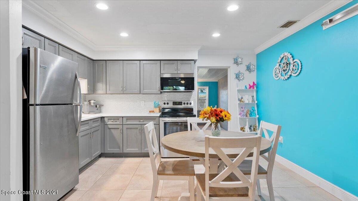 2255 King Richard Road Melbourne, FL 32935 - Photo 6 of 23 a kitchen with stainless steel appliances granite countertop a dining table chairs refrigerator and microwave