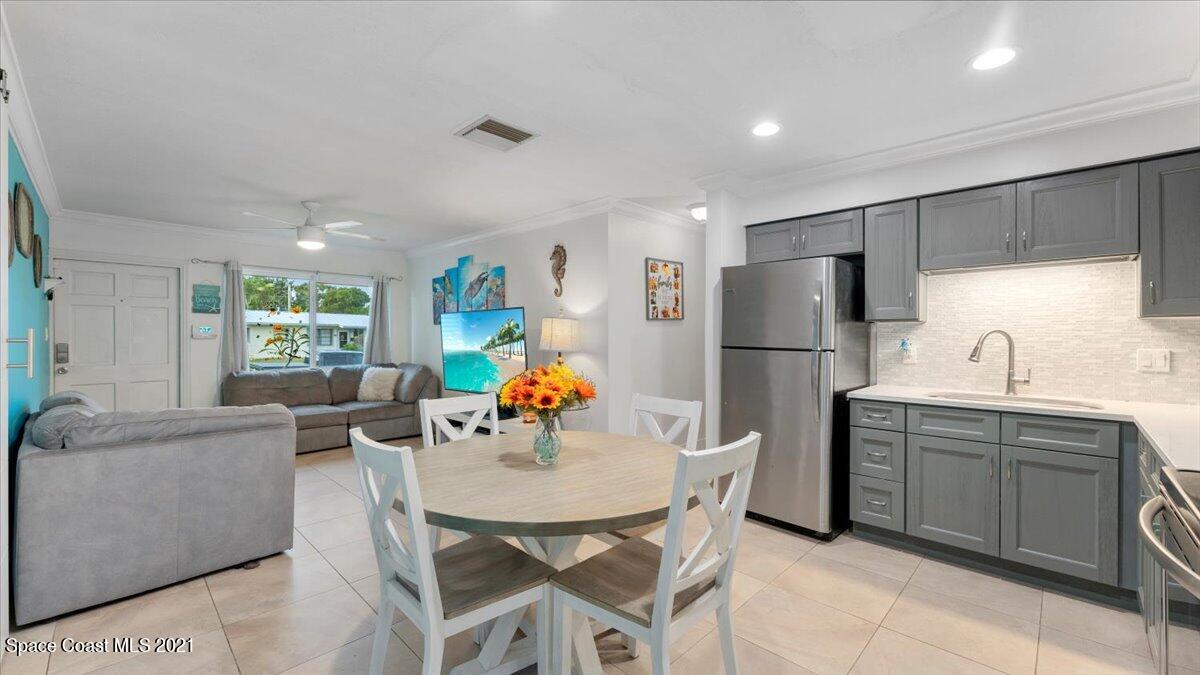 2255 King Richard Road Melbourne, FL 32935 - Photo 8 of 23 a kitchen with a refrigerator a sink dishwasher a dining table and chairs with wooden floor