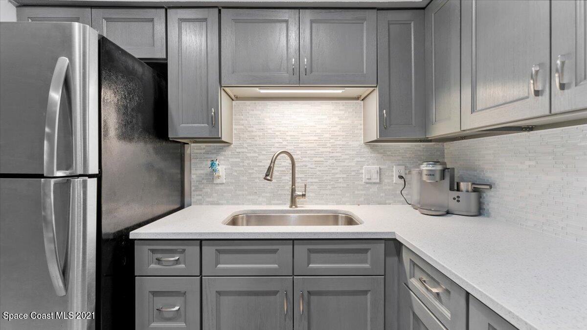 2255 King Richard Road Melbourne, FL 32935 - Photo 9 of 23 a kitchen with a sink and refrigerator