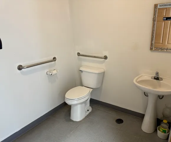 a white toilet sitting next to a white wall