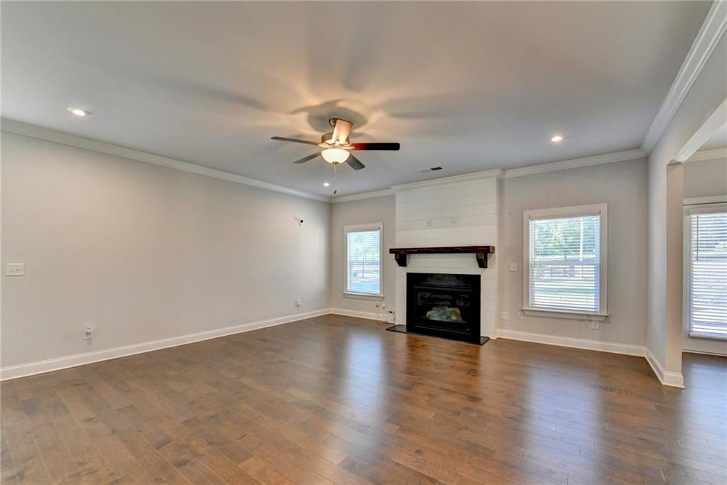4548 Red Blossom Trail Southwest Powder Springs, GA 30127 - Photo 15 of 72 an empty room with windows fireplace and wooden floor