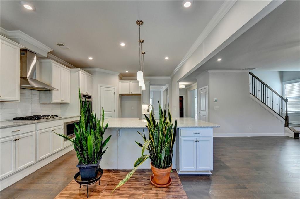 4548 Red Blossom Trail Southwest Powder Springs, GA 30127 - Photo 22 of 72 a kitchen with stainless steel appliances a potted plant on the kitchen table and chairs