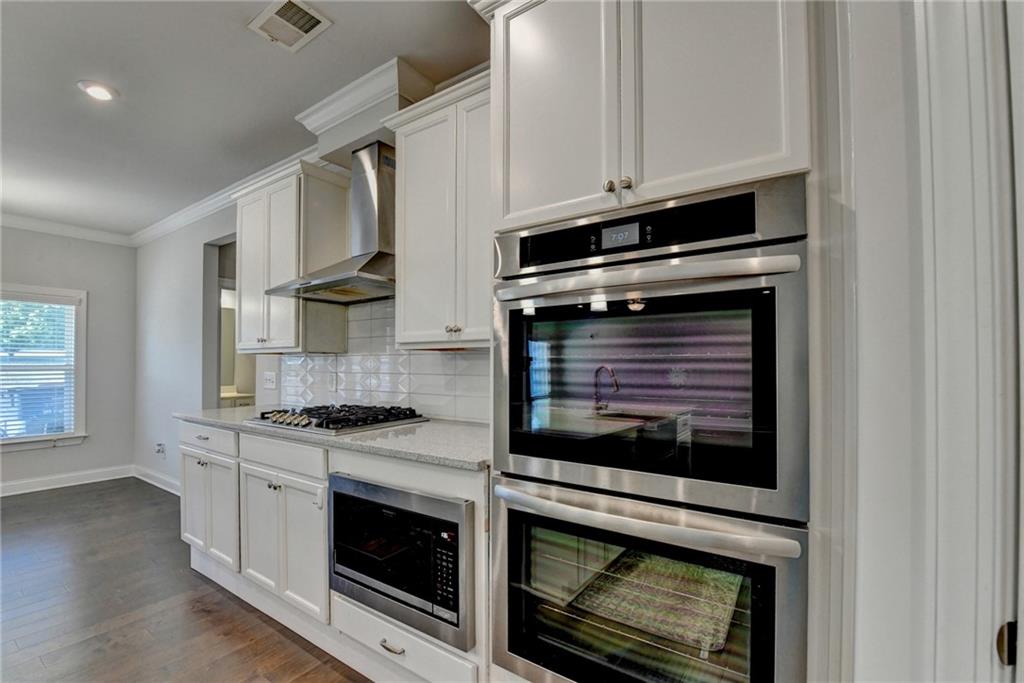 4548 Red Blossom Trail Southwest Powder Springs, GA 30127 - Photo 26 of 72 a kitchen with granite countertop white cabinets stainless steel appliances and a sink