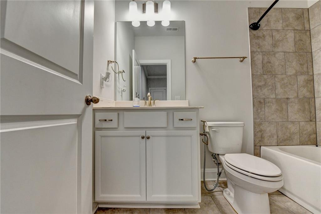 4548 Red Blossom Trail Southwest Powder Springs, GA 30127 - Photo 32 of 72 a bathroom with a toilet a sink and mirror