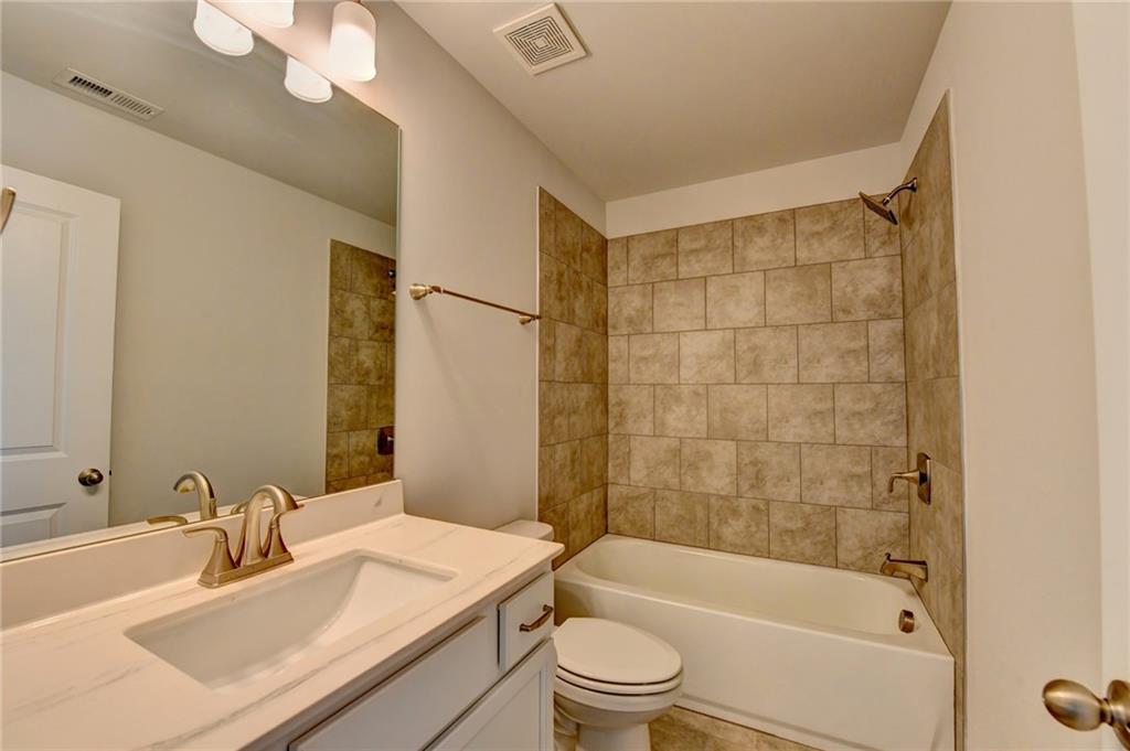 4548 Red Blossom Trail Southwest Powder Springs, GA 30127 - Photo 48 of 72 a bathroom with a bathtub a sink a toilet and a mirror