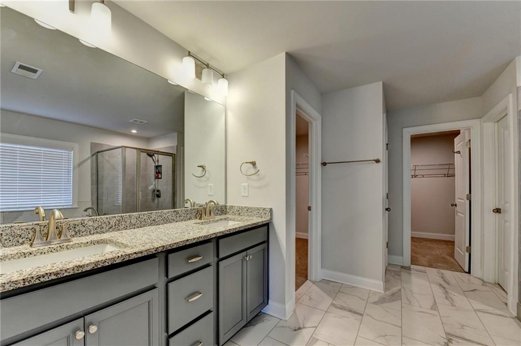 4548 Red Blossom Trail Southwest Powder Springs, GA 30127 - Photo 59 of 72 a bathroom with a granite countertop sink and a mirror