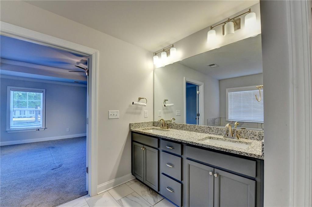 4548 Red Blossom Trail Southwest Powder Springs, GA 30127 - Photo 60 of 72 a bathroom with a granite countertop sink and a mirror