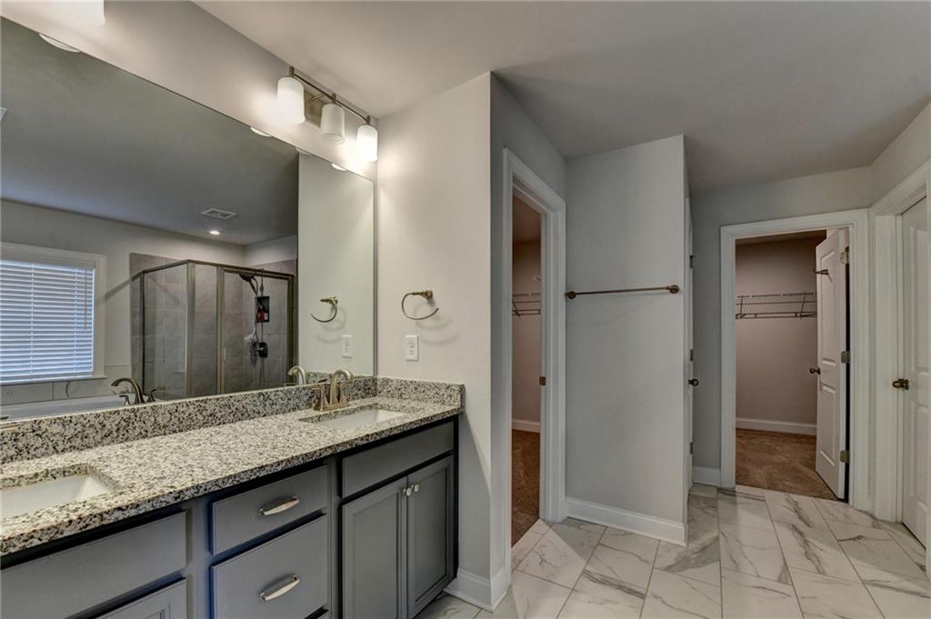 4548 Red Blossom Trail Southwest Powder Springs, GA 30127 - Photo 65 of 72 a bathroom with a granite countertop sink and a mirror