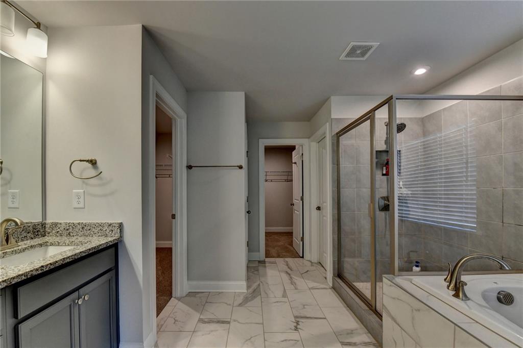 4548 Red Blossom Trail Southwest Powder Springs, GA 30127 - Photo 66 of 72 a bathroom with a granite countertop sink a mirror and a bathtub