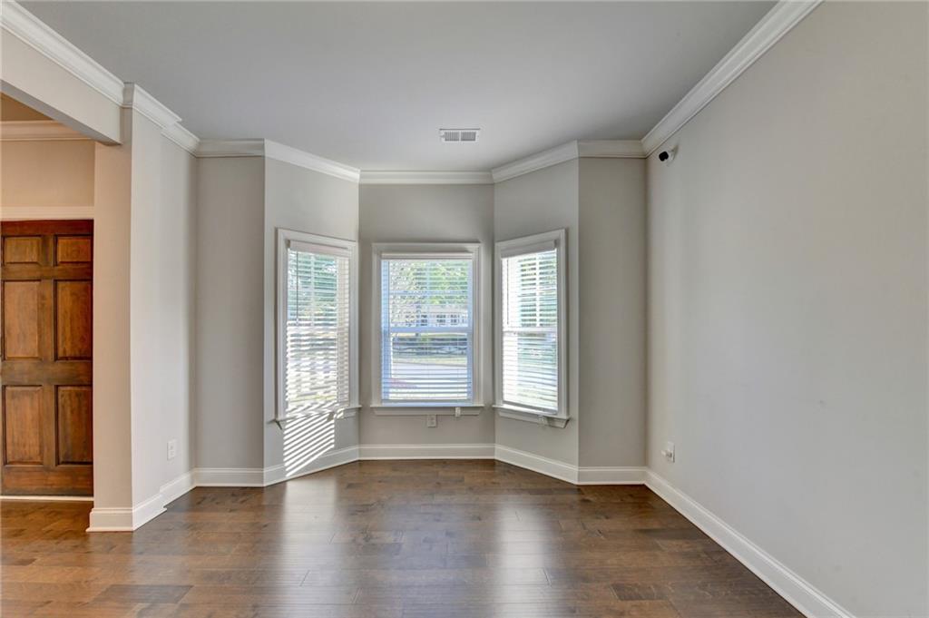 4548 Red Blossom Trail Southwest Powder Springs, GA 30127 - Photo 9 of 72 a view of an empty room with wooden floor and a window