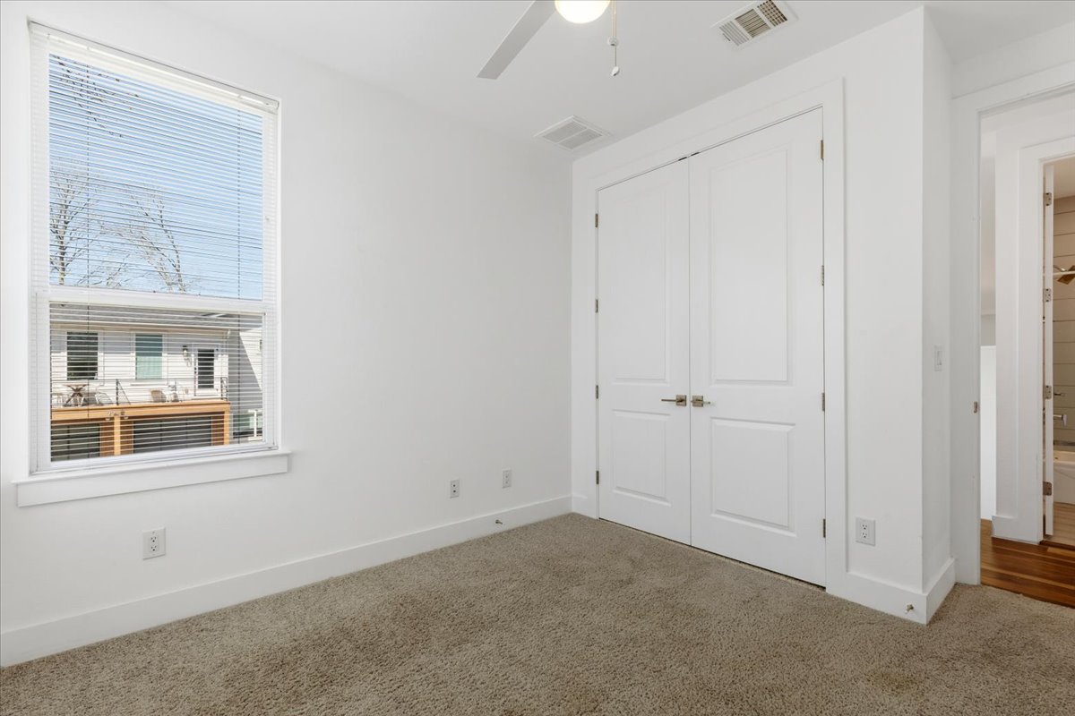 1114 Walton Lane, Unit A Austin, TX 78721 - Photo 16 of 36 Unfurnished bedroom featuring carpet flooring, a closet, and ceiling fan