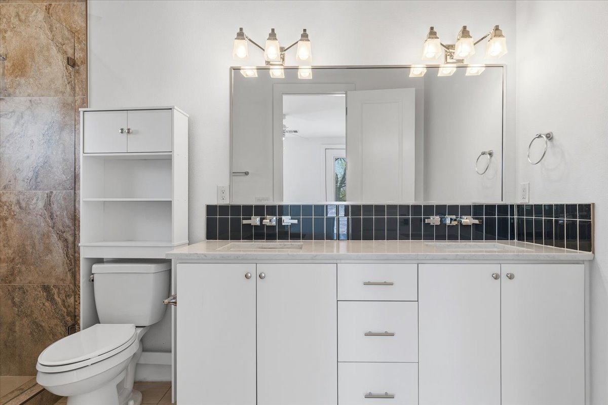 1114 Walton Lane, Unit A Austin, TX 78721 - Photo 18 of 36 Full bathroom featuring double vanity, tasteful backsplash, and a tile shower