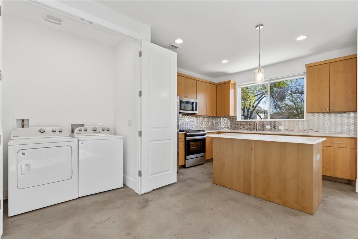1114 Walton Lane, Unit A Austin, TX 78721 - Photo 6 of 36 Kitchen with a kitchen island, stainless steel appliances, independent washer and dryer,