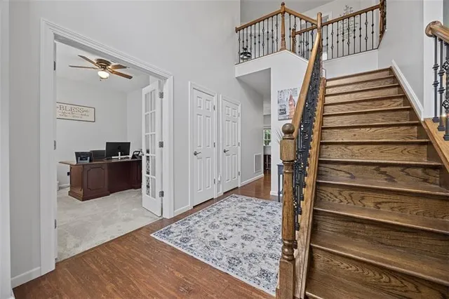 a view of a hallway with wooden floor and staircase