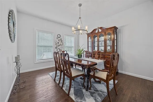 a dining room with furniture a chandelier and wooden floor