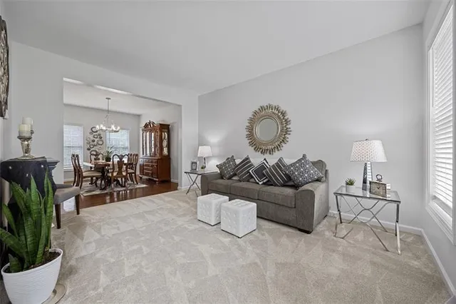 a living room with furniture a chandelier and a large window