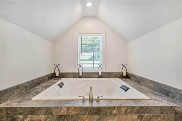 a bathroom with a granite countertop sink and a window