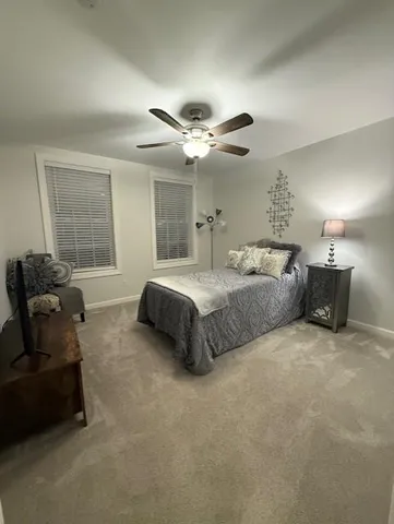 a spacious bedroom with a bed and ceiling fan