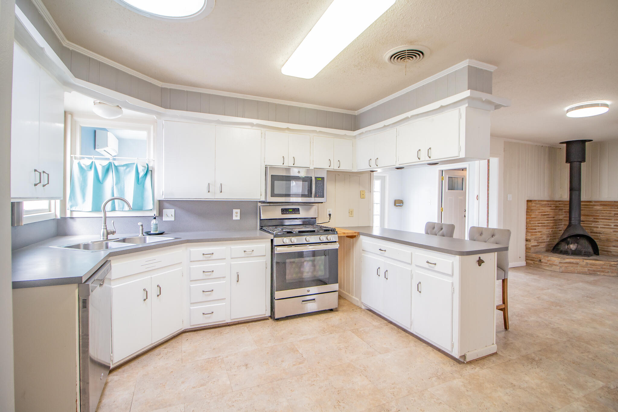 2806 58th Street Lubbock, TX 79413 - Photo 14 of 35 a kitchen with granite countertop a sink stove and cabinets