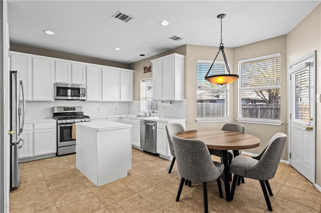3508 Bratton Ridge Crossing Austin, TX 78728 - Photo 3 of 18 A well-lit kitchen with sleek white cabinetry and a practical center island for culinary endeavors.