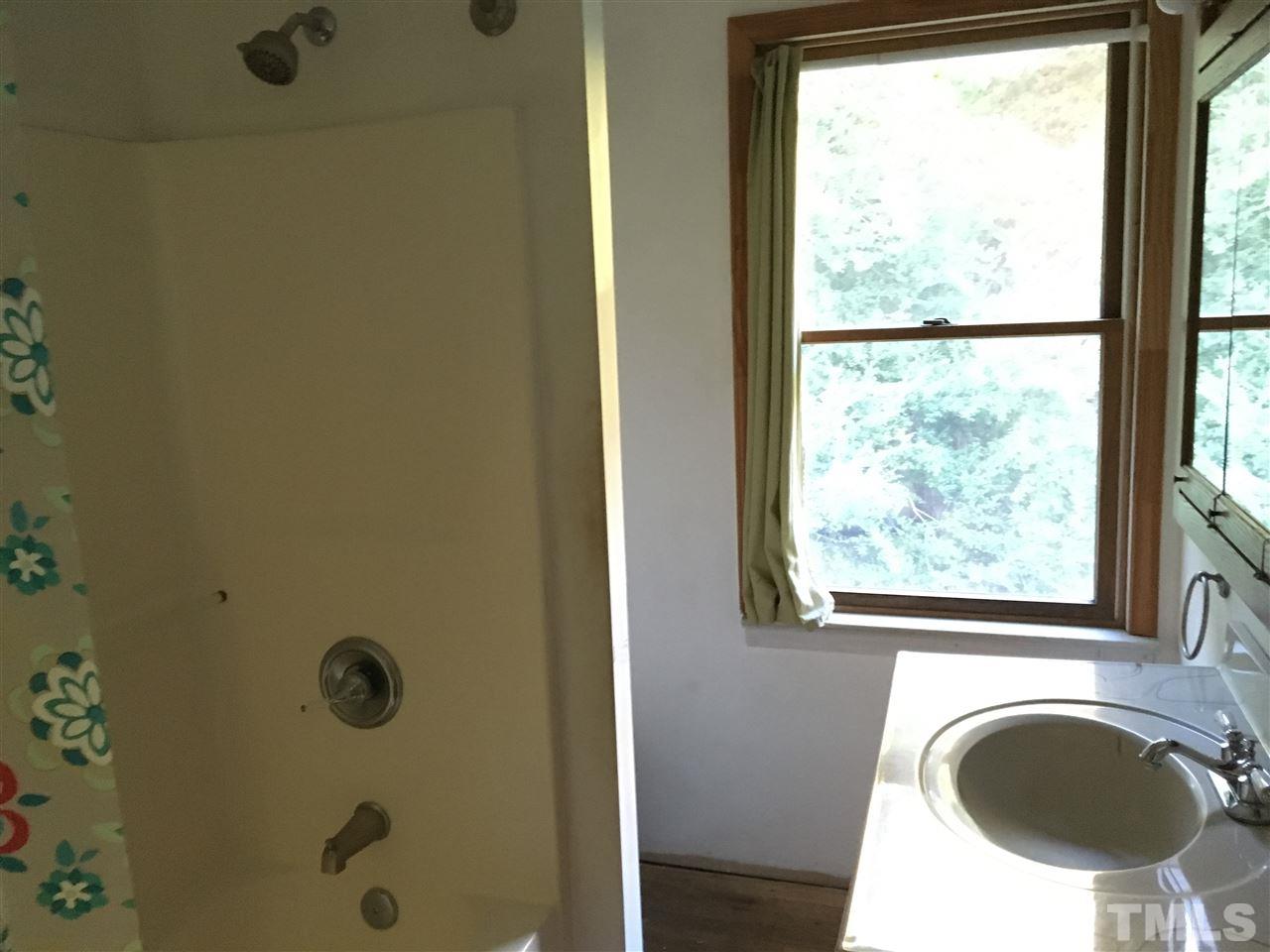 9516 Virgilina Road Roxboro, NC 27574 - Photo 12 of 21 a bathroom with a sink a mirror and a window