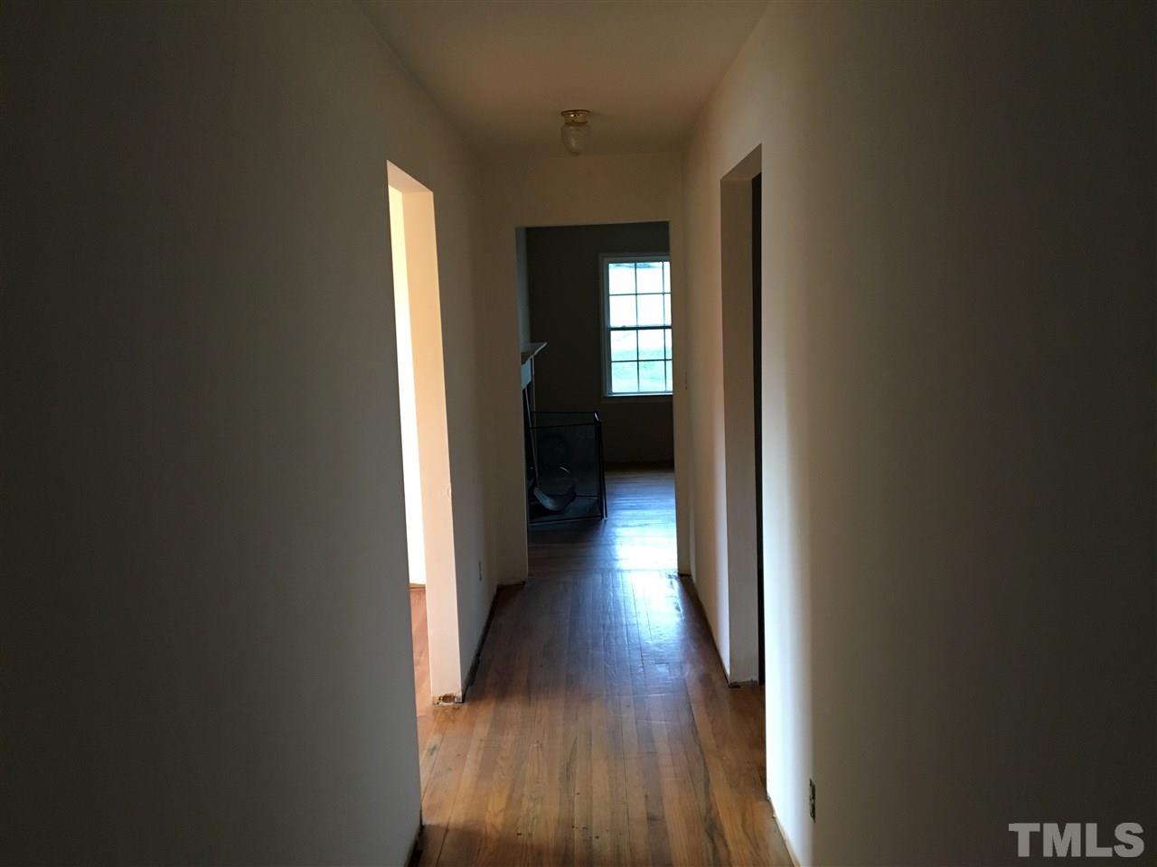 9516 Virgilina Road Roxboro, NC 27574 - Photo 14 of 21 a view of a hallway with wooden floor and a livingroom