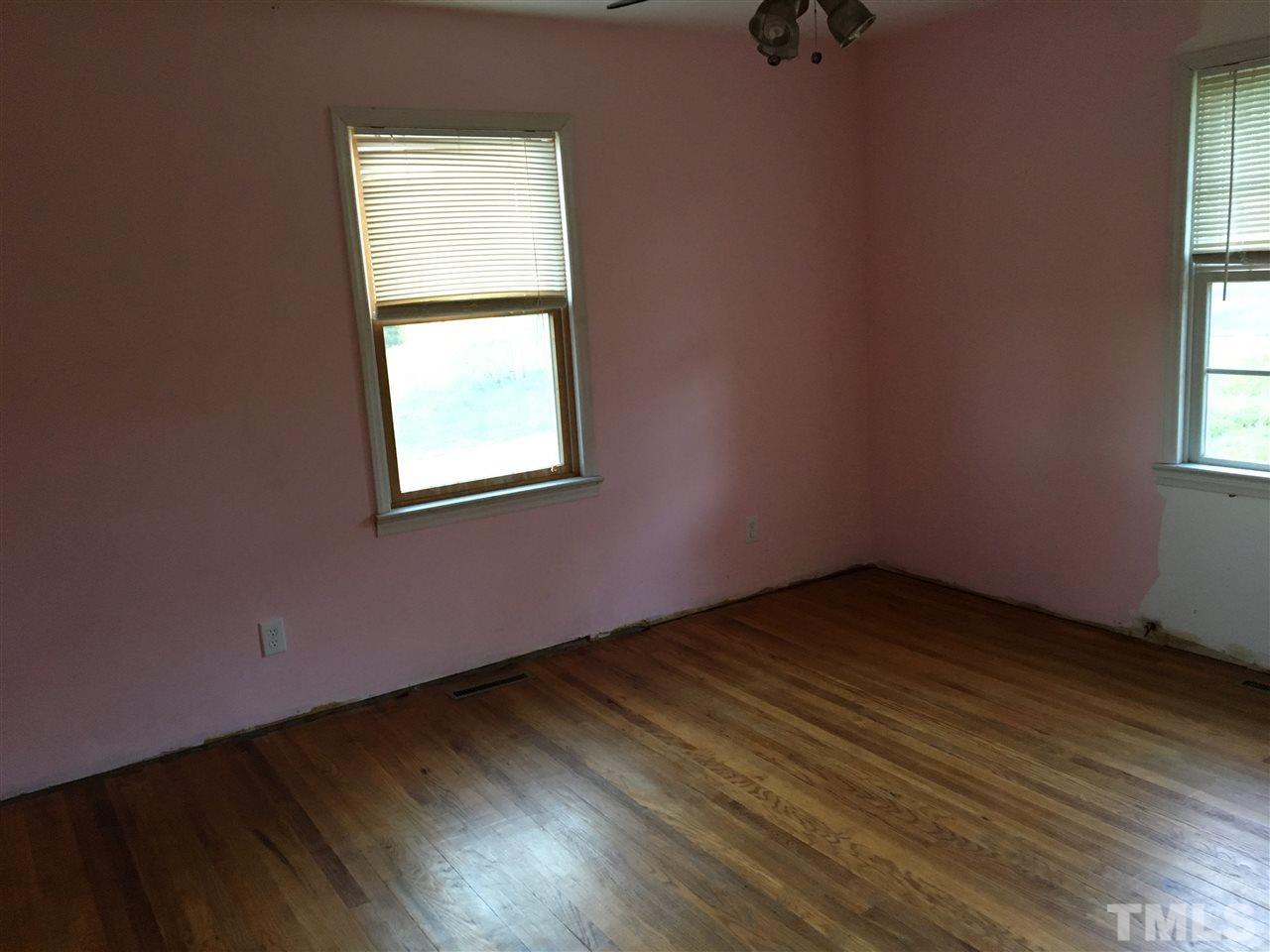 9516 Virgilina Road Roxboro, NC 27574 - Photo 16 of 21 an empty room with wooden floor and windows