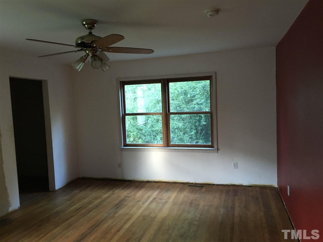 9516 Virgilina Road Roxboro, NC 27574 - Photo 17 of 21 an empty room with wooden floor fan and windows