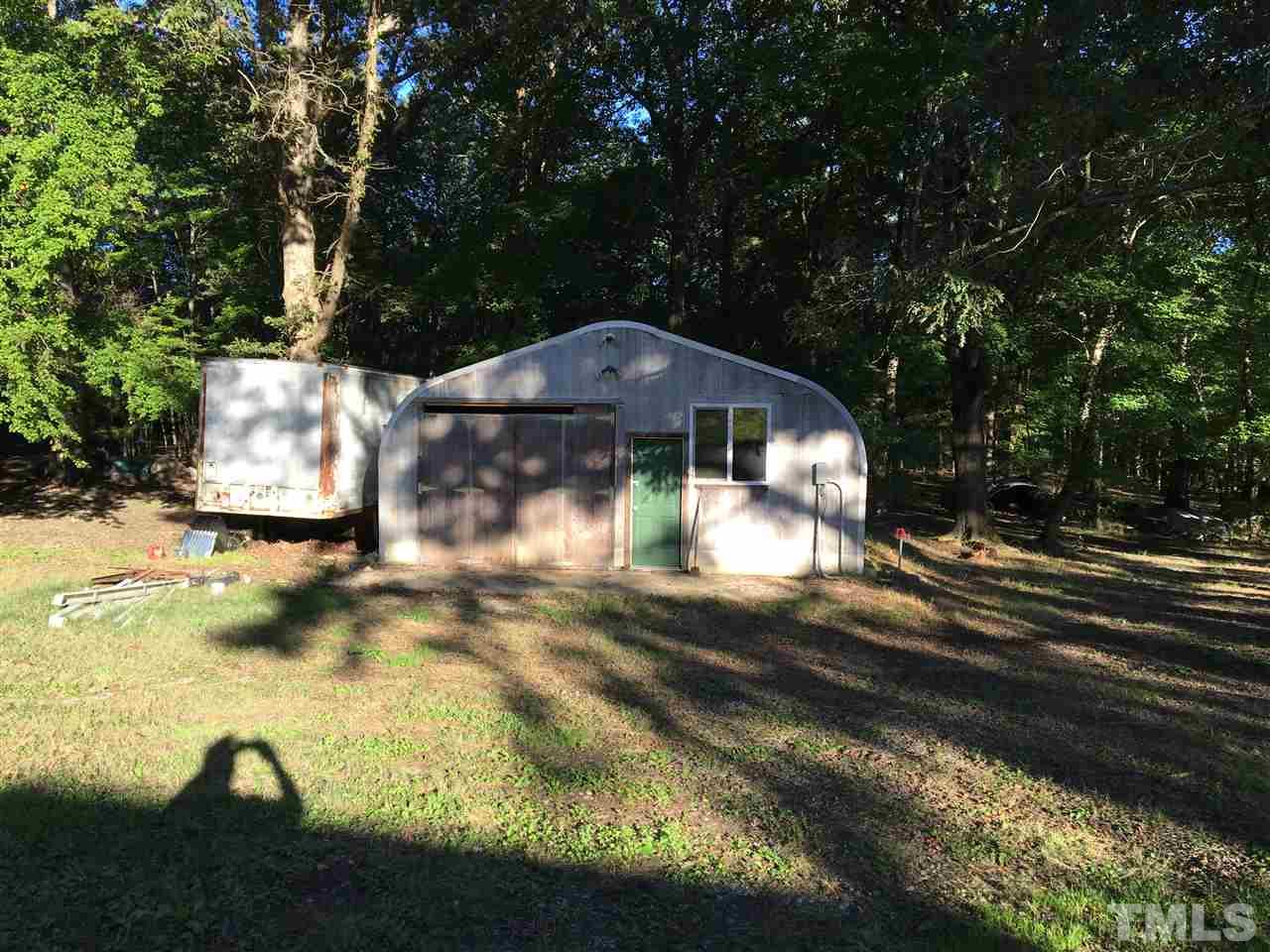 9516 Virgilina Road Roxboro, NC 27574 - Photo 5 of 21 a view of a yard in front of a house with large trees