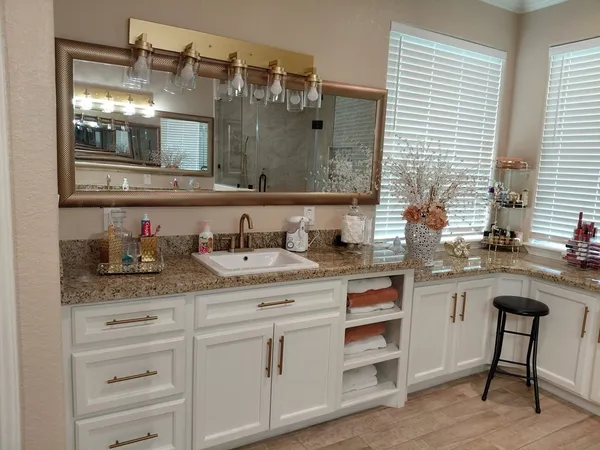 a bathroom with a granite countertop sink and a mirror