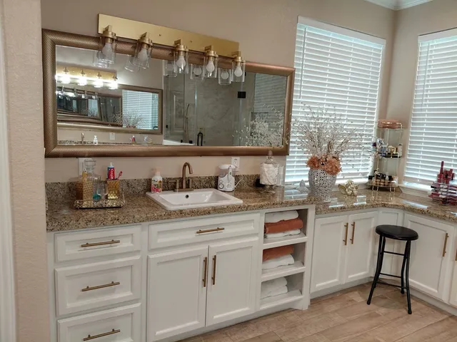 a bathroom with a granite countertop sink and a mirror