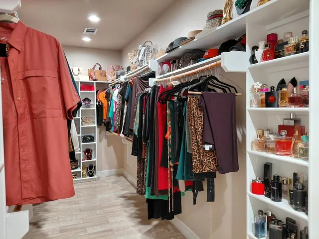 a view of walk in closet with clothes and shoes