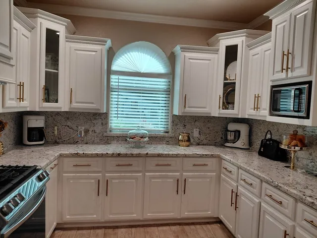 a kitchen with stainless steel appliances granite countertop a sink and a granite counter tops