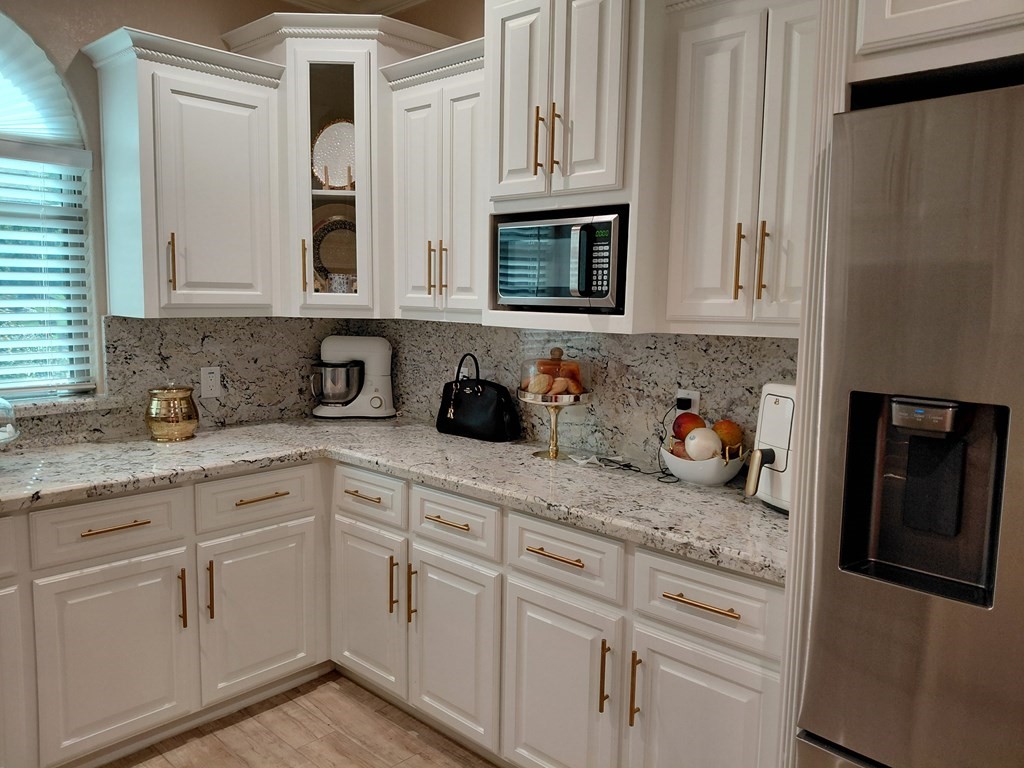 309 Hickman Lane Angleton, TX 77515 - Photo 22 of 33 a kitchen with granite countertop white cabinets and stainless steel appliances