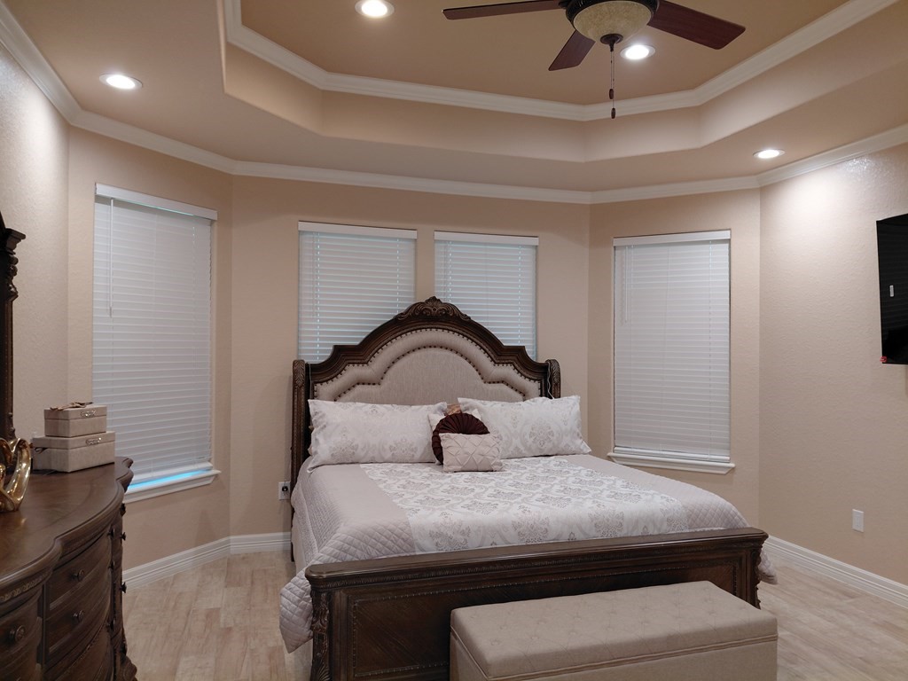 309 Hickman Lane Angleton, TX 77515 - Photo 4 of 33 a bedroom with a bed and a chandelier