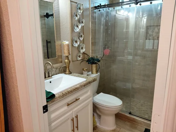 a bathroom with a sink a toilet and shower