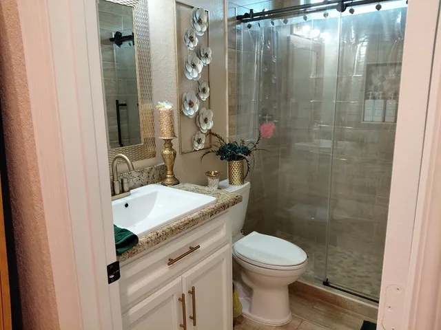a bathroom with a sink a toilet and shower