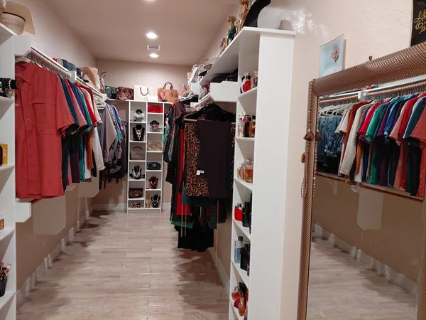 a view of walk in closet with clothes and shoes