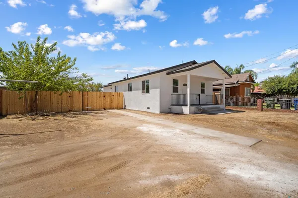 a view of a house with a backyard and a tree