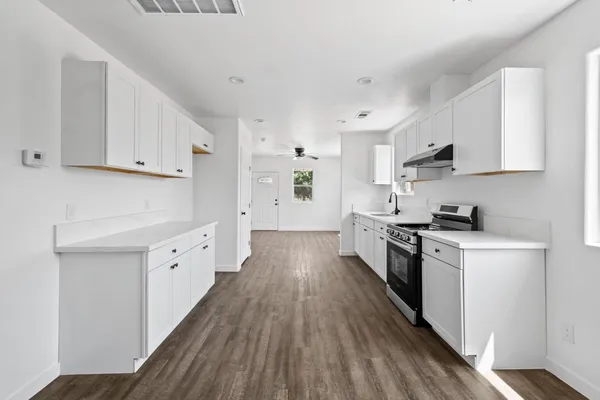 a kitchen with cabinets a sink and wooden floor