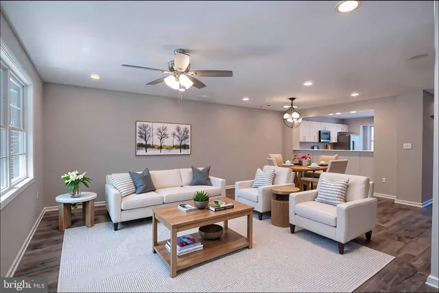 a living room with furniture kitchen and a chandelier