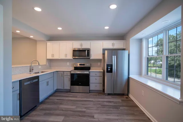 a kitchen with stainless steel appliances granite countertop a refrigerator sink and stove