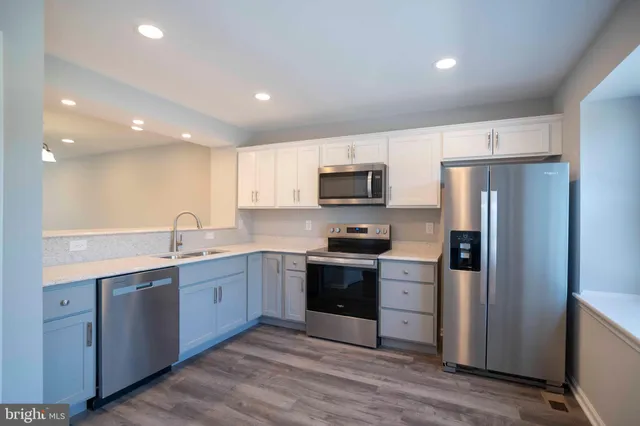 a large kitchen with cabinets stainless steel appliances and a counter space