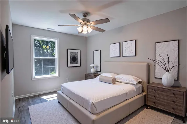 an empty room with wooden floor closet and windows