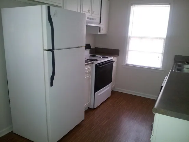 a white refrigerator freezer and a stove sitting inside of a kitchen